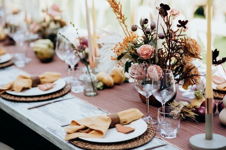 Table décorée avec fleurs et vaisselle élégante.