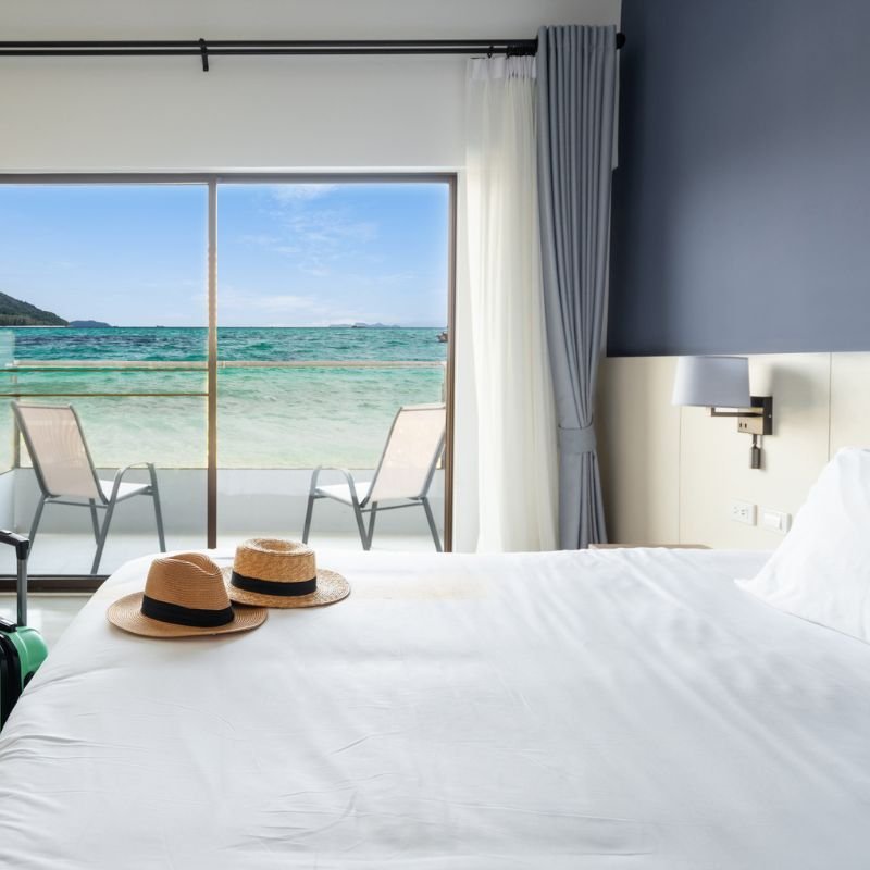 Chambre avec vue sur mer, chaises et chapeau.